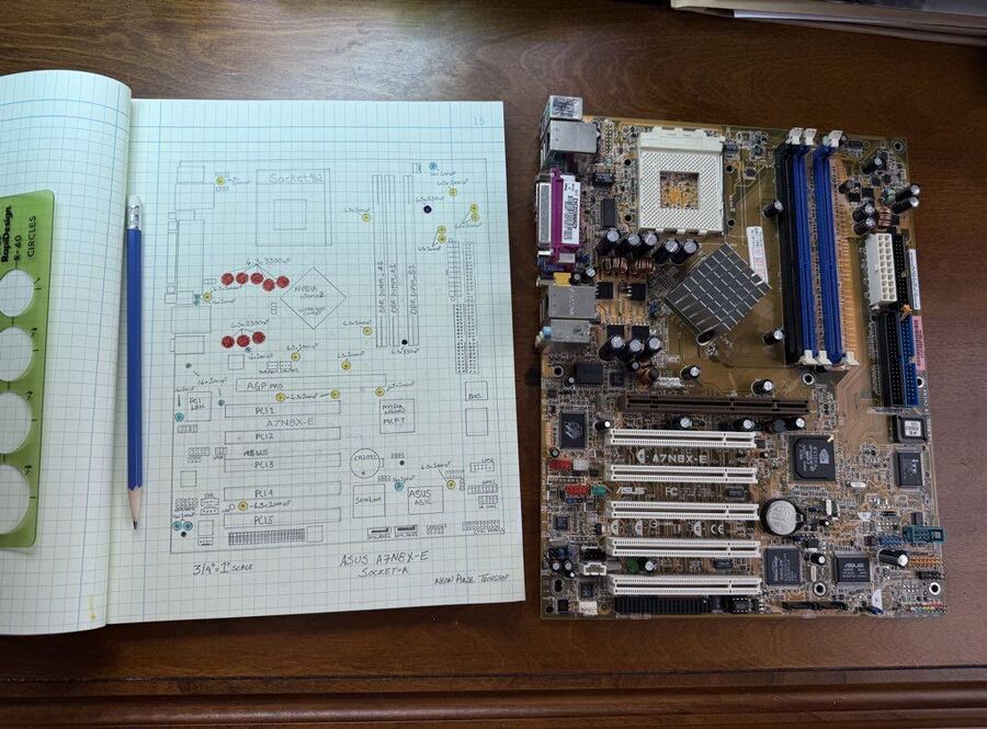 Hand-drawn capacitor map beside the motherboard it describes
