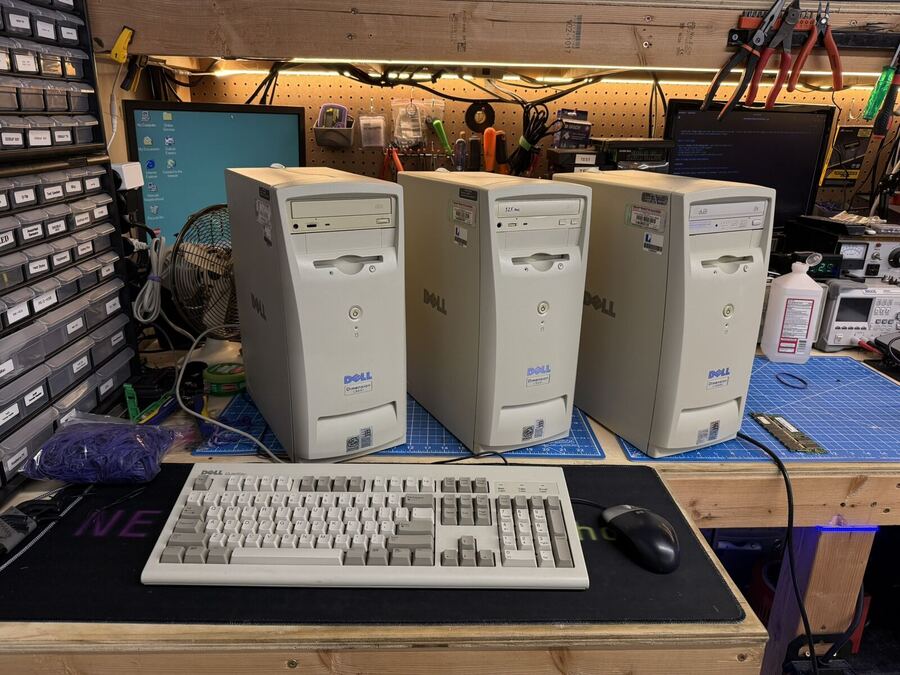 Three restored beige OEM towers with keyboards on the workbench