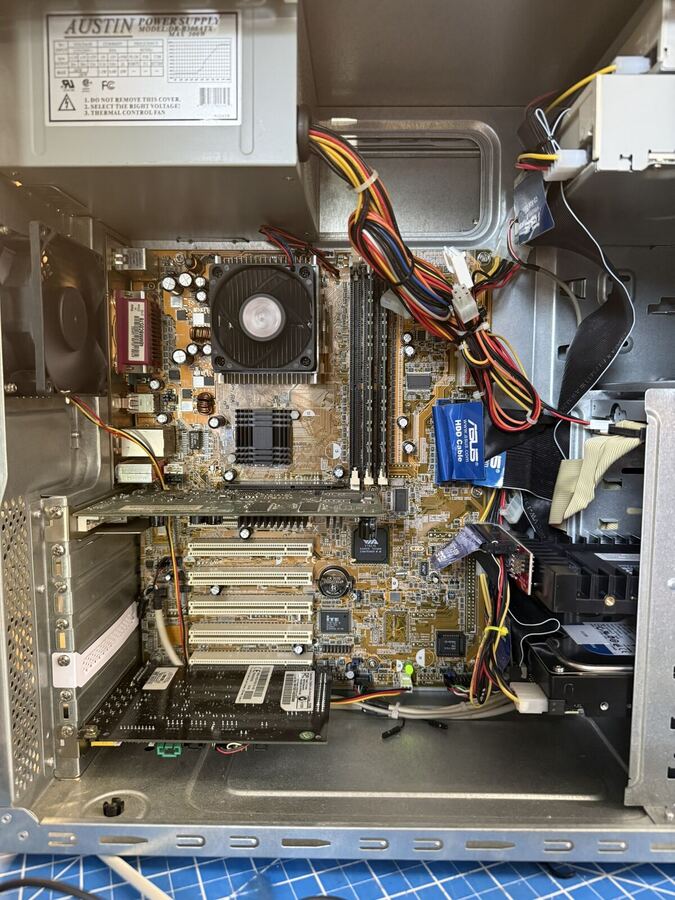 Open beige PC case on the bench mid-repair